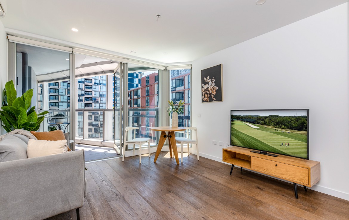 Living area in SDA accommodation in Moonee Ponds with view to balcony and surrounding apartment buildings