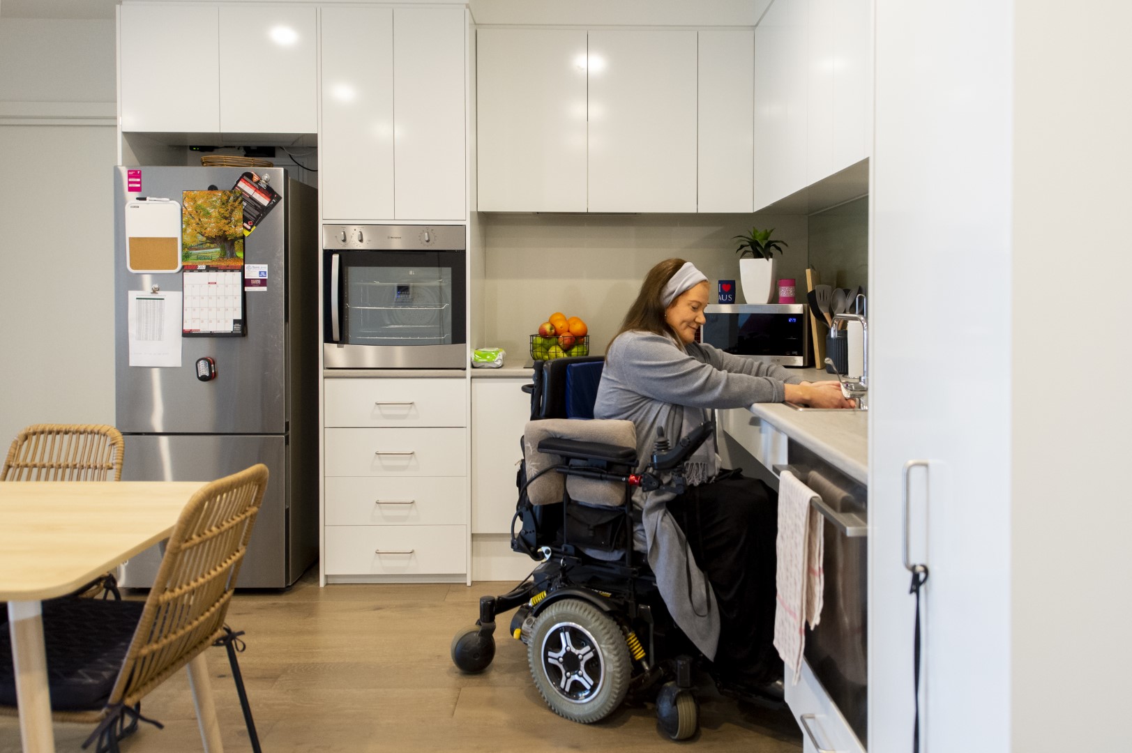 NDIS participant using the sink in the kitchen area of an SDA property