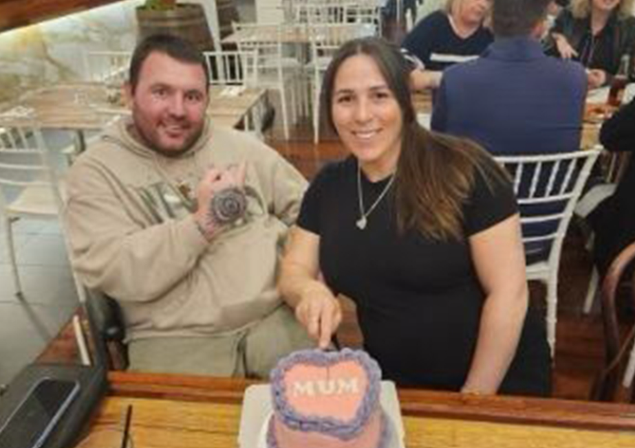 Chris with support worker cutting a cake