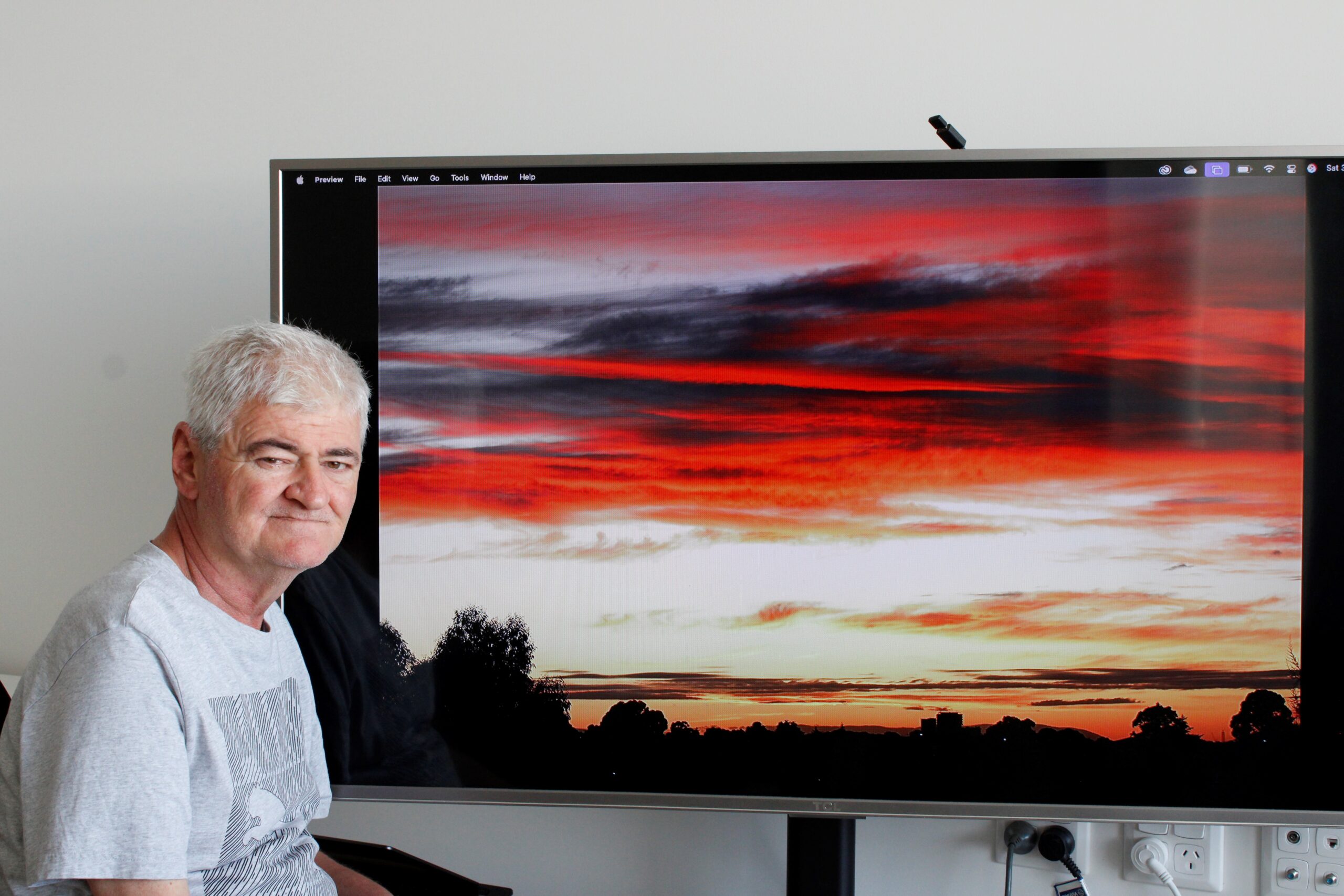 recep with one of his photos on a tv display